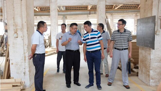 周杏武(左二)在基荣木业生产车间了解该企业安全生产责任和措施落实