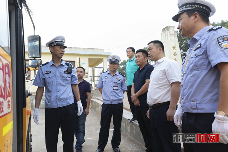 姚书茂(右二)等在黄谷市小学检查校车安全