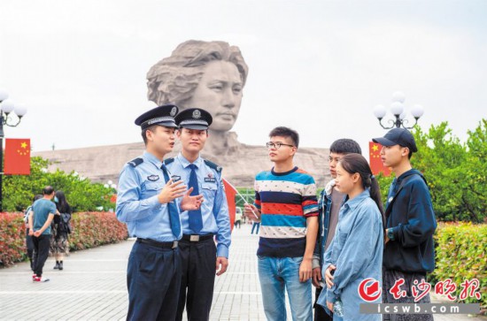 在橘子洲头,民警在巡逻过程中与游客交流。 长沙晚报通讯员 彭滔 摄